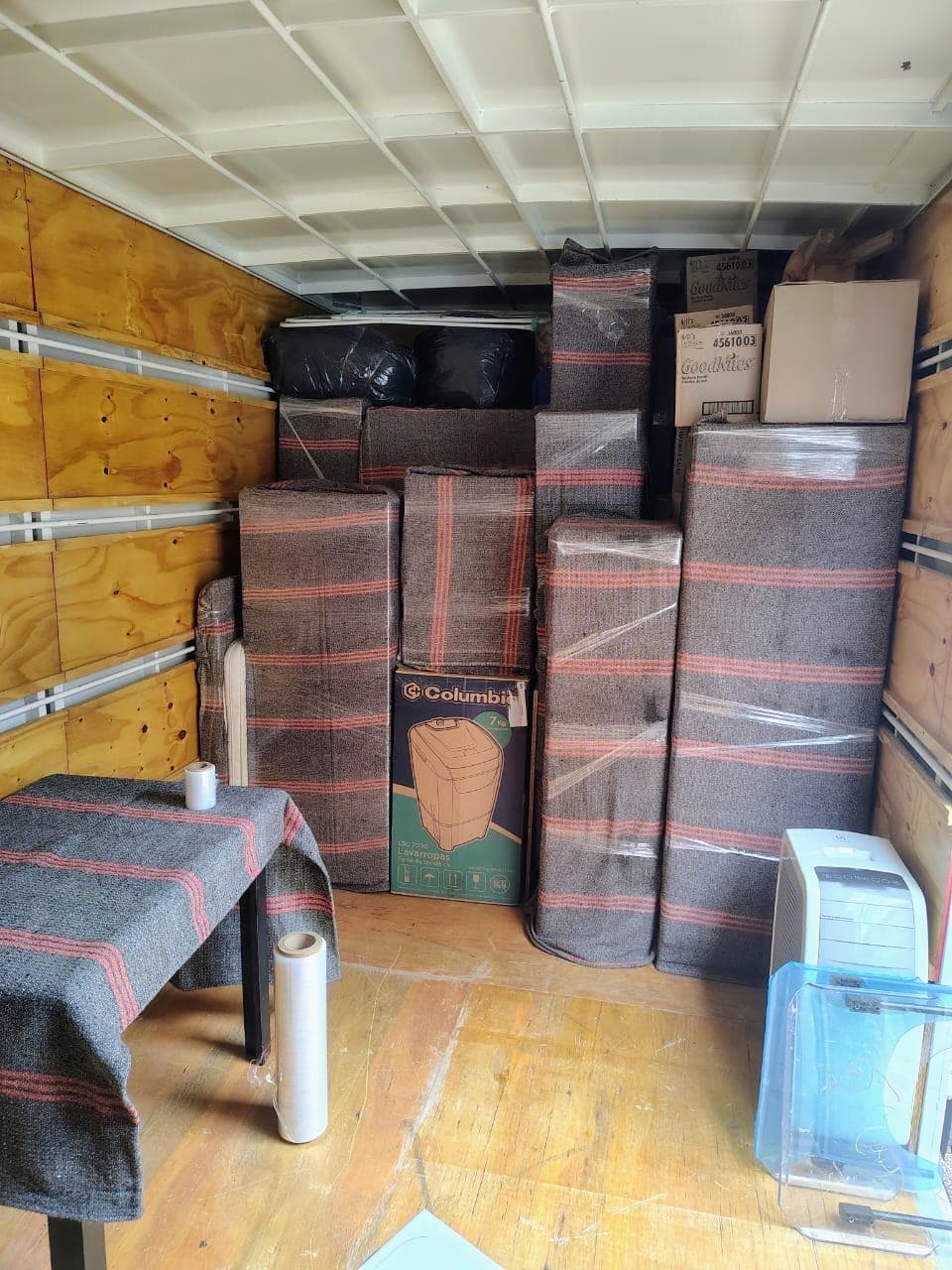 Interior del camión de mudanza cargado con muebles embalados